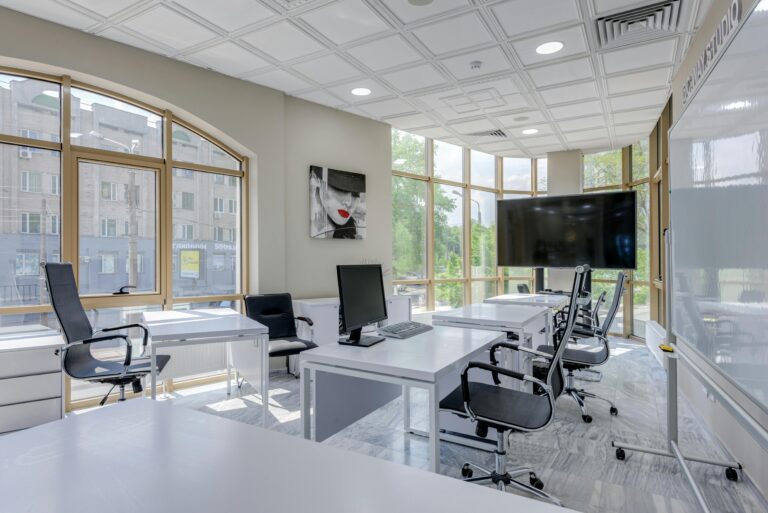 Contemporary minimalist office with glass windows and ergonomic chairs.